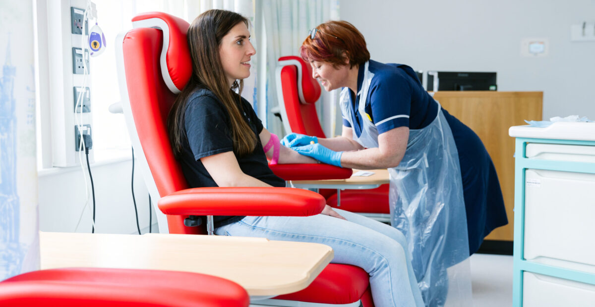 A nurse taking blood from a smiling patient