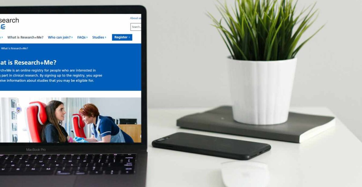 A laptop showing the Research+Me website on screen