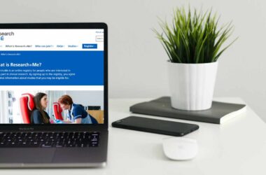 A laptop showing the Research+Me website on screen